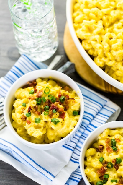 Macaroni en kaas gegarneerd met spekjes en bieslook.