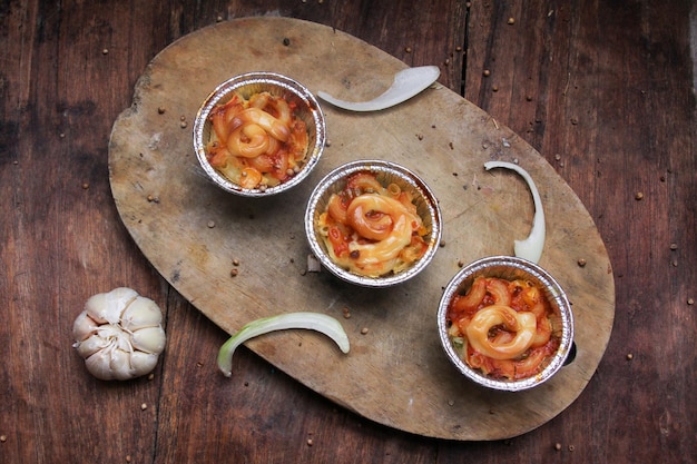 Macaroni met bolognesesaus geserveerd op een snijplank.