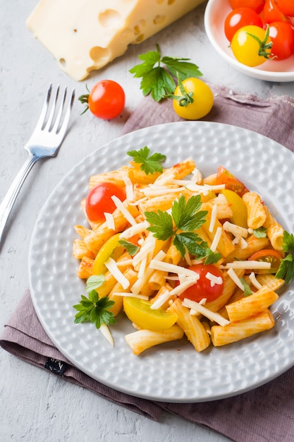 Macaroni, pasta in tomato sauce and cheese in a plate on a woode