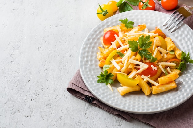 Макароны, макароны в томатном соусе и сыр в тарелке на деревянном столе