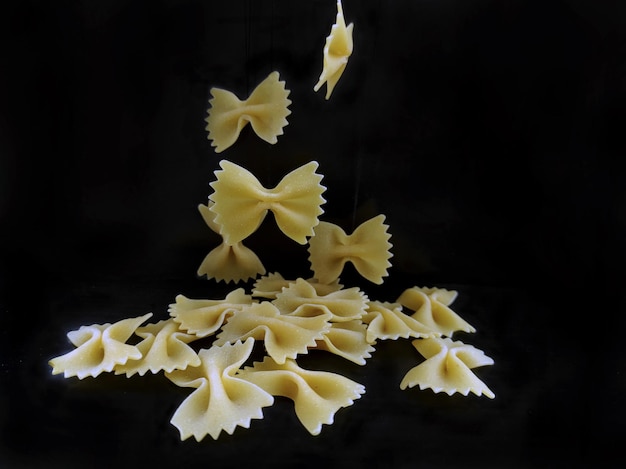 Macaroni scattered from a jar closeup on a black background