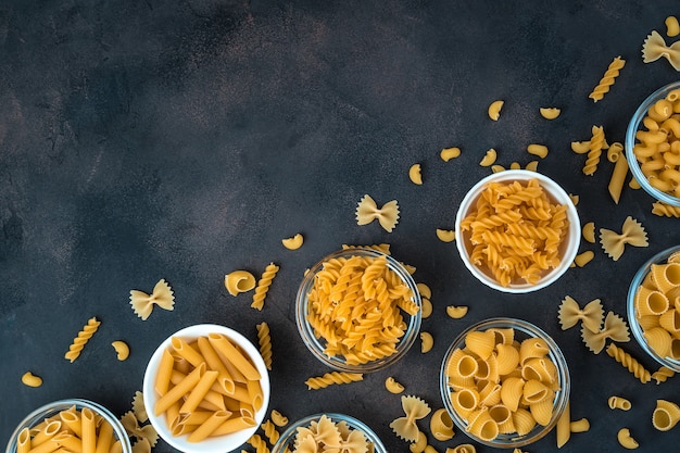 Macaroni van verschillende soorten op een donkere achtergrond.