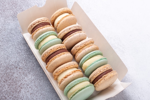 Macarons in box on stone background. Delicious french macarons. Copy space, top view - Image