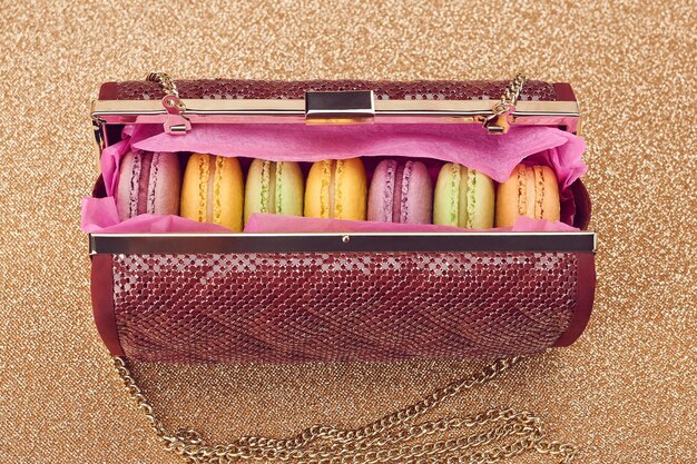 Macarons in shiny fashion handbag on goldvintage