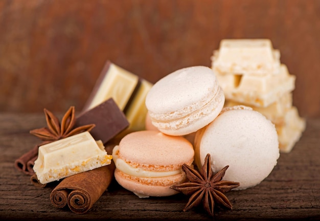 Macarons with chocolate and spices on a wooden background