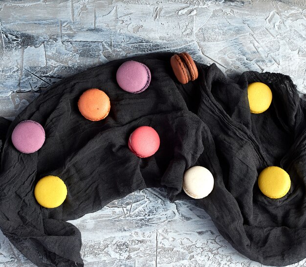 Macarons with cream on a black gauze towel