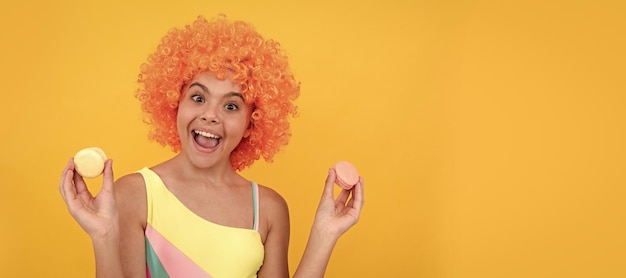 Macaroon cookie gelukkige jeugd verjaardagsfeestje grappige jongen in clown pruik houden franse macaron tiener