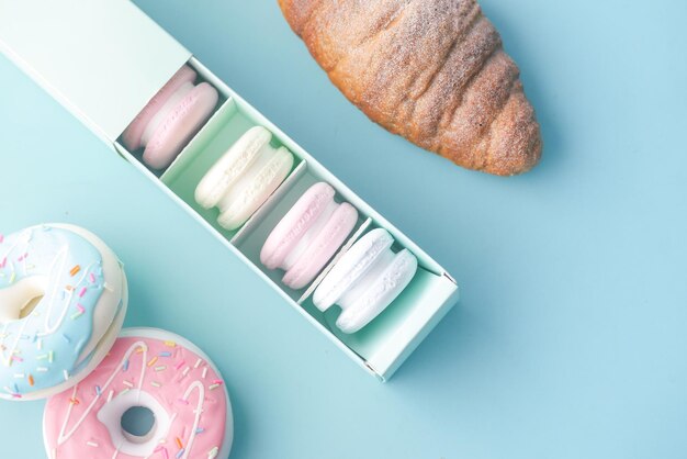 Macaroon in a paper box on light green background