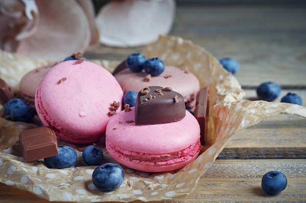 Macaroon with fresh blueberries and chocolate on rustic wooden table