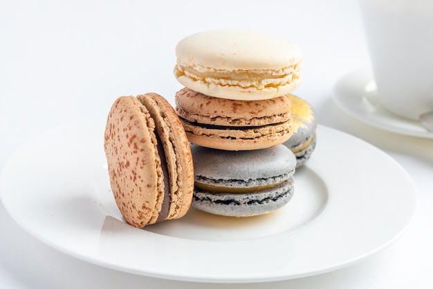 Macaroons cake with a cup of coffee on a light background closeup