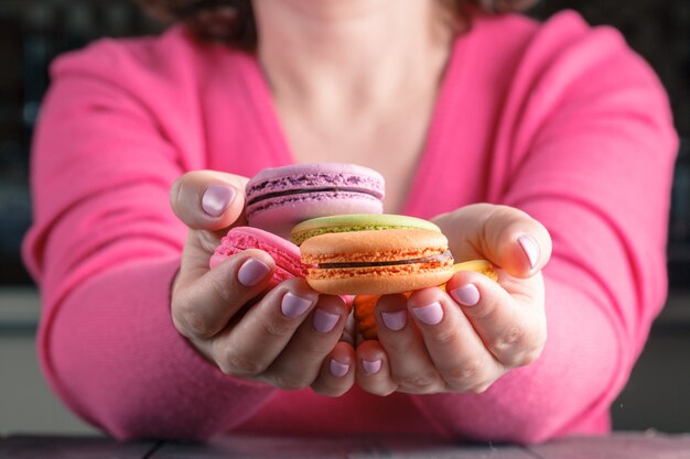 Macaroons colored in the hands of woman