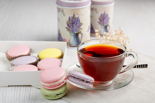 Macaroons and a cup of tea on a light wood kitchen table 