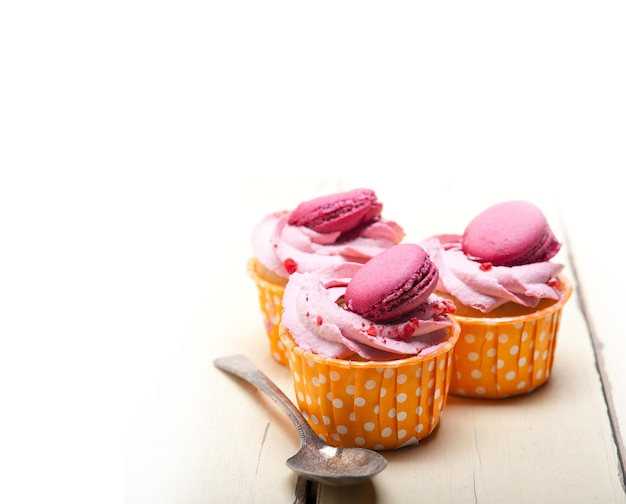 Macaroons on cupcakes over white background