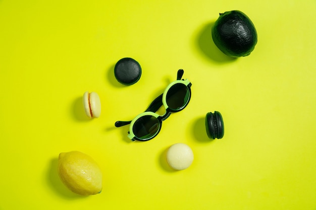 Macaroons and lemons. Monochrome stylish and trendy composition in yellow color on  background. Top view, flat lay. Pure beauty of usual things around. Copyspace for ad. Holiday, food, fashion.