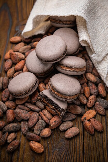 Macaroons with cocoa beans on a wooden table