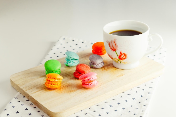 Photo macaroons with coffee cup on cutting board