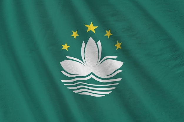 Macau flag with big folds waving close up under the studio light indoors the official symbols and colors in banner