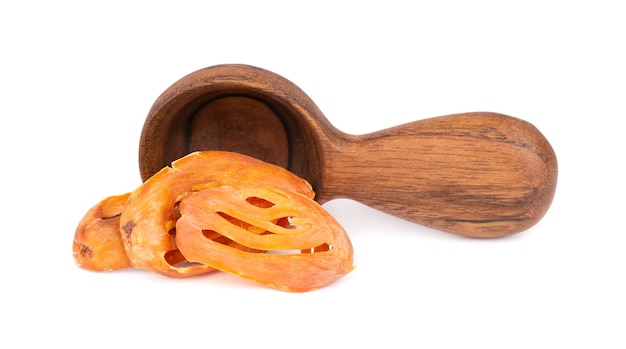 Mace in a wooden spoon, isolated on white background. Nutmeg flower, myristica fragrans. Natural spice, asian seasoning.