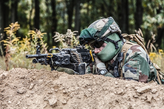 Machine gunner of 1st Marine Infantry Parachute Regiment RPIMA firing from defensive position trench