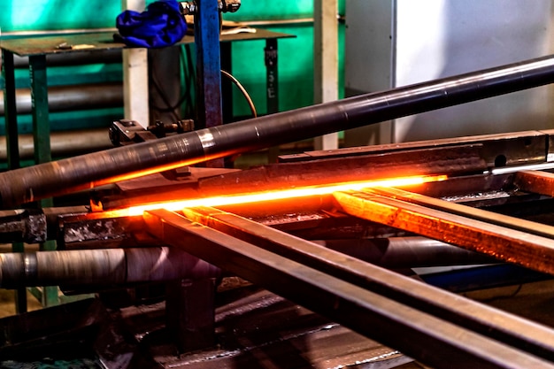 金属の誘導加熱機誘導炉で加熱された金属棒溶銑加工工場の工業工場での金属加工