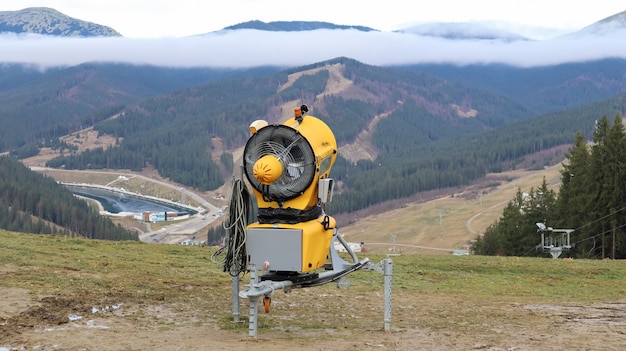 Machinegeweer, sneeuwkanon voor de productie van kunstmatige sneeuw in de bergen, voorbereiding om te skiën. Sneeuw maken. Sneeuwproductie door het oppompen van water en perslucht wordt gebruikt in skigebieden.