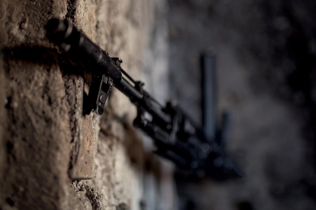 Machinepistool kalashnikov AK-47 tegen de muur