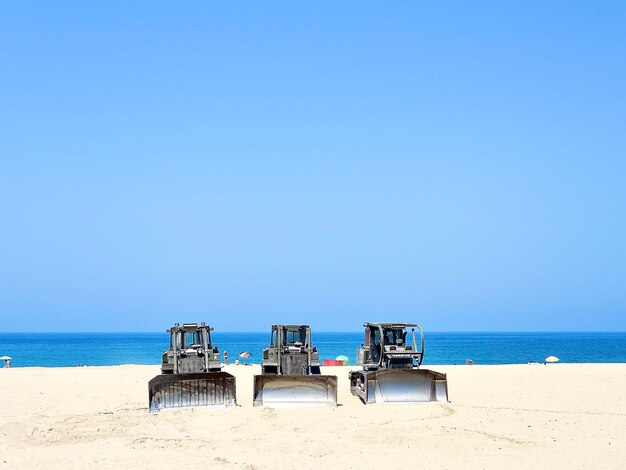 Machinery on beach against clear sky