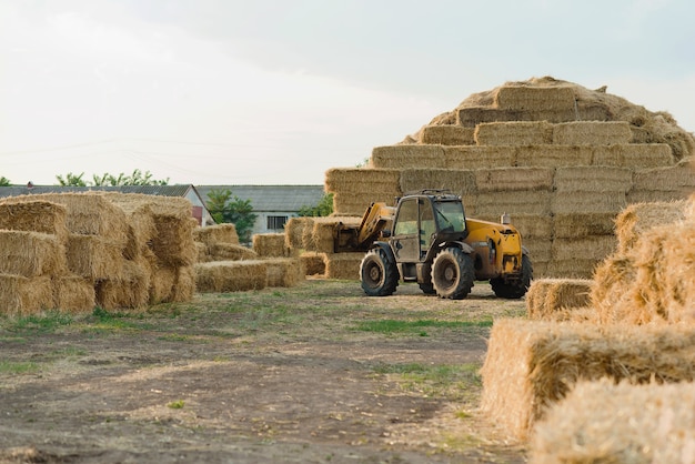 Foto machines stapelen hooibalen op boerderijgebied