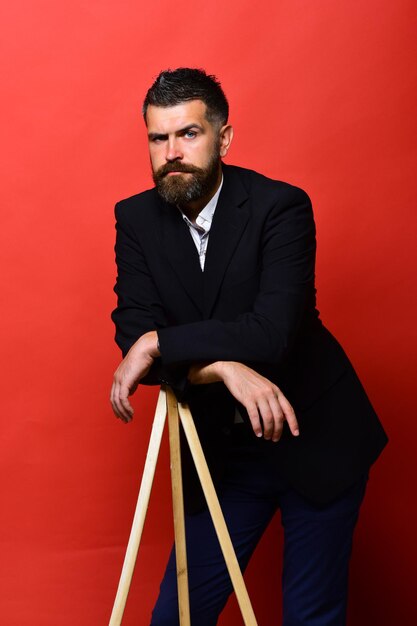 Macho man leans on tripod photo tripod on red background Photographer