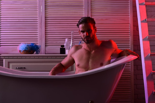 Macho sitting naked in bathtub with seductive look