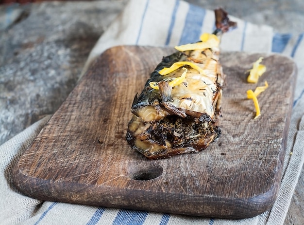 Mackerel fish on a wooden board and an old towel