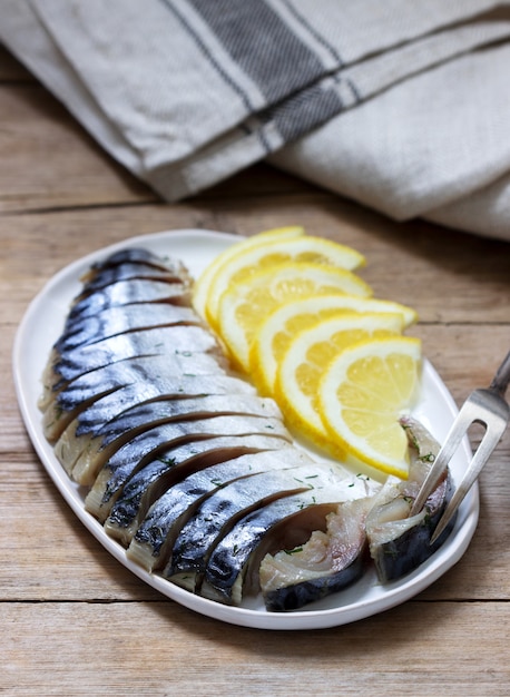 Mackerel glavrax with lemon slices on a wooden surface