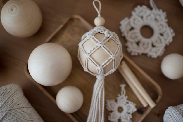 Macramé decor in een houten kist, kerstbal en sterren, handgemaakte hobbymaterialen.