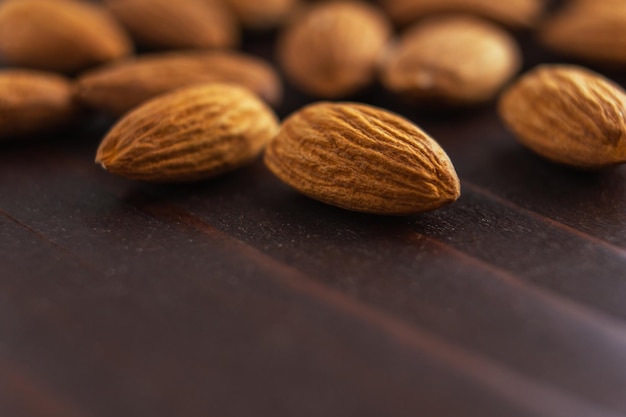 Macro of almonds on wooden table. Organic health protein vegetarian food. Selective focus copy space