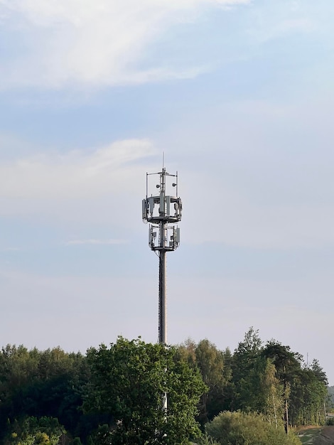 Macro base station 5g radio network telecommunication equipment\
with radio modules and smart antennas mounted on a metal against\
cloulds sky background telecommunication tower of 4g and 5g\
cellular