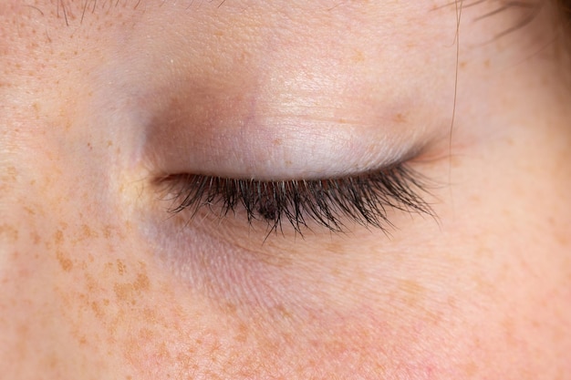 Macro of a closed and relaxed girl eye details of the eyelid in relief