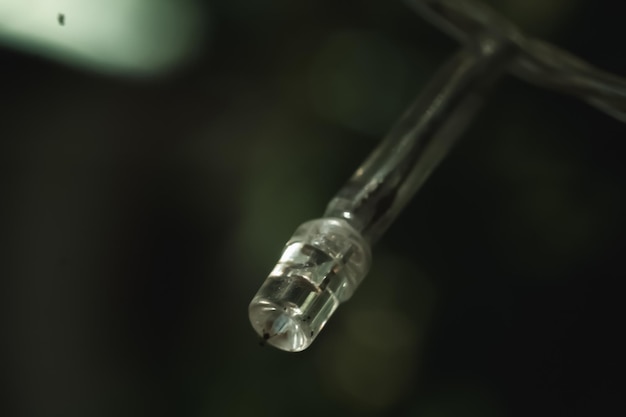 Macro closeup old small burned out white pale plastic light
emitting diode led strip lamp of electric garland blur background
outdoor object technologies burnt wire spoiled product
defective