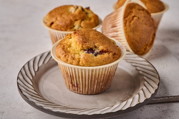 Macro cupcakes with cherries on plate on light background selective focus