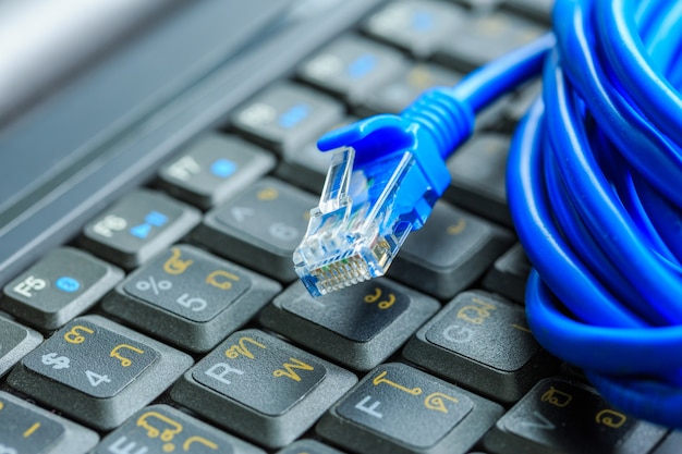 Photo macro of internet cable on keyboard of computer