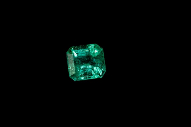 Macro mineral Emerald gemstone faceted on black background