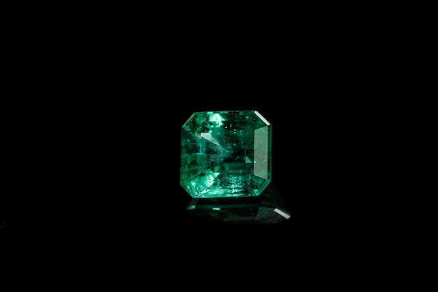 Photo macro mineral emerald gemstone faceted on black background