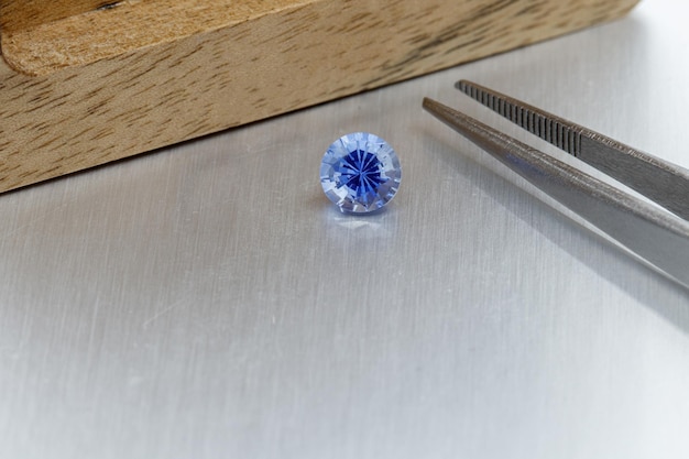 Macro mineral faceted stone Sapphire on a gray background