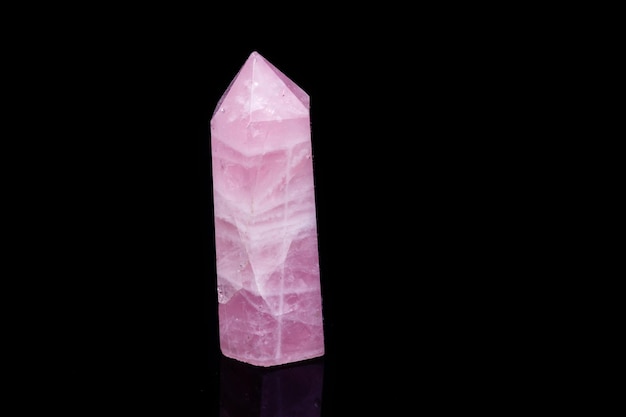 Macro mineral pink quartz crystal on a black background