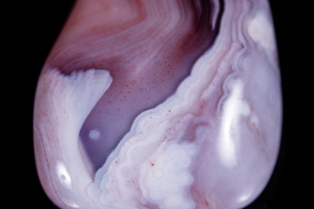 Macro mineral stone Agate pink Persian on a black background