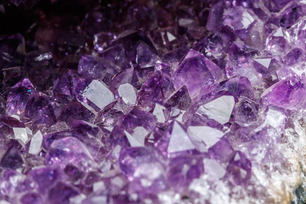 Macro Mineral Stone Amethysts in the rock on a white background