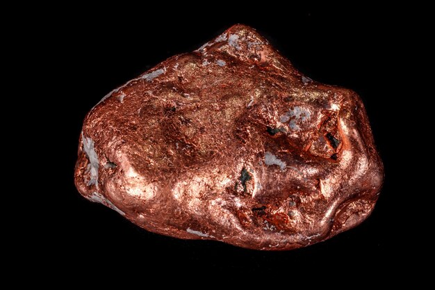 Macro mineral stone of a copper nugget on a microcline on a black background