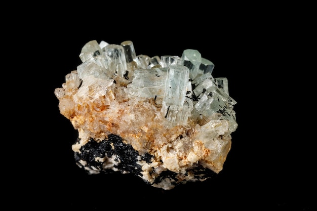 Macro mineral stone crystals Aquamarine in rock on a black background
