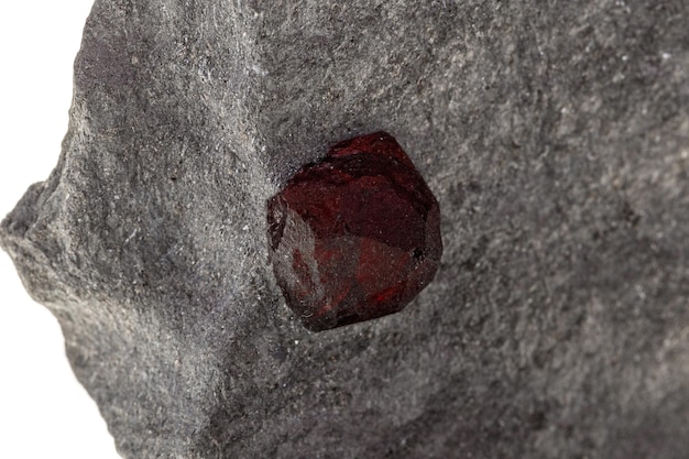 Макроминеральный камень Гранат в скале на белом фоне