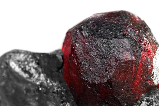 Macro mineral stone garnet in the rock on a white background