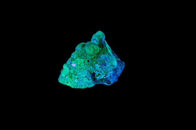 Макроминеральный каменный опал под ультрафиолетовым светом на черном фоне